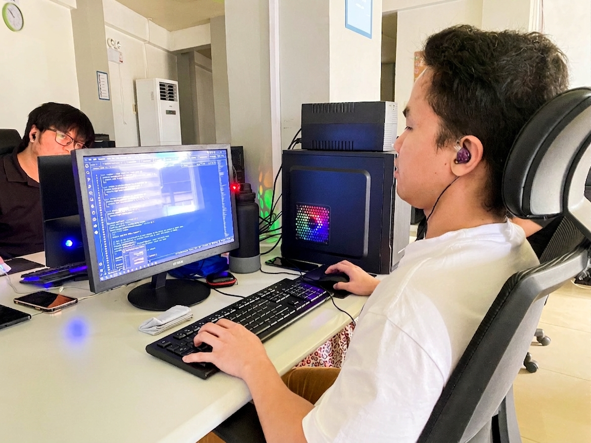 Programmer working on a computer in a modern office environment.