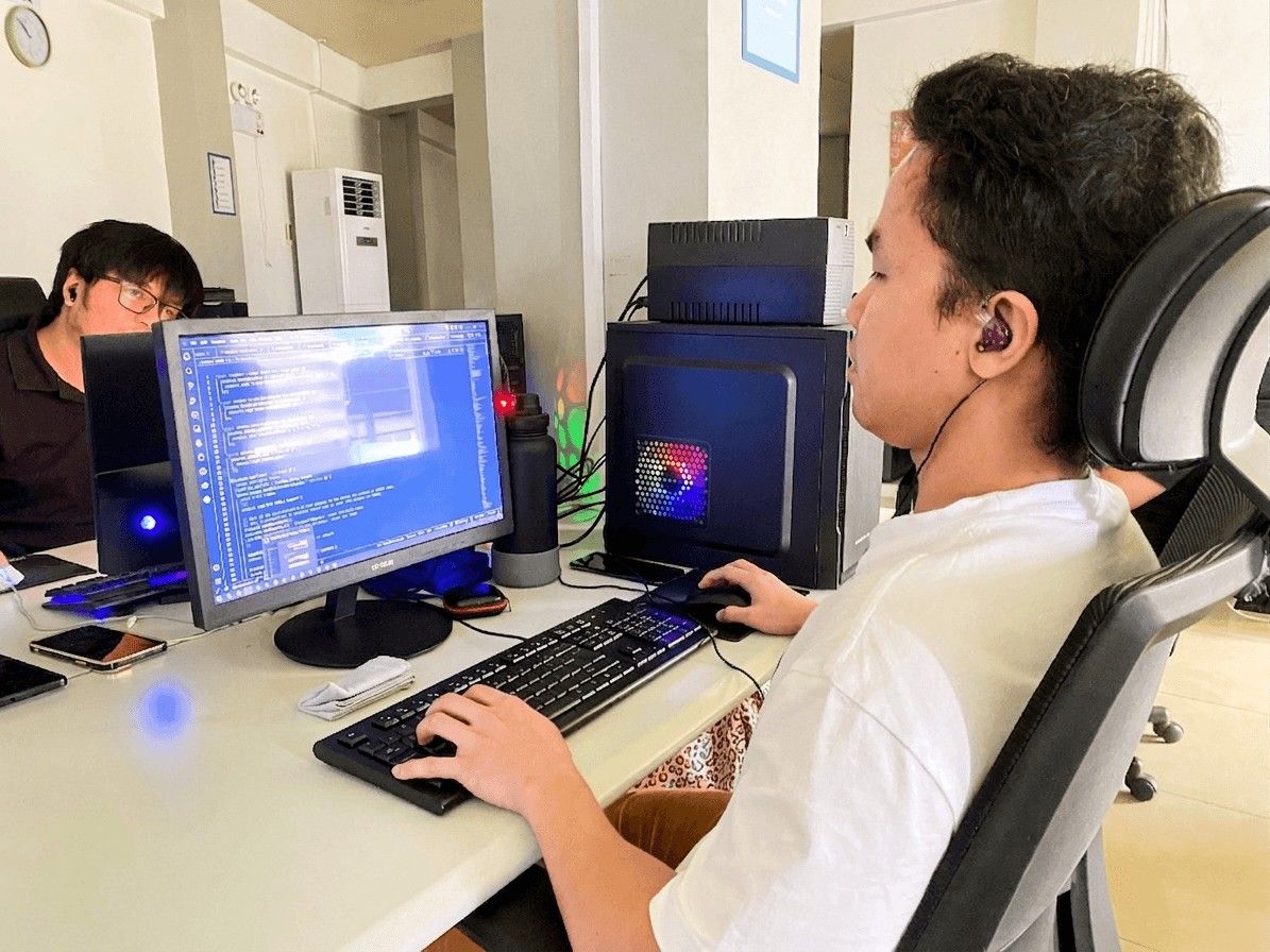 Programmer working on a computer in a modern office environment.