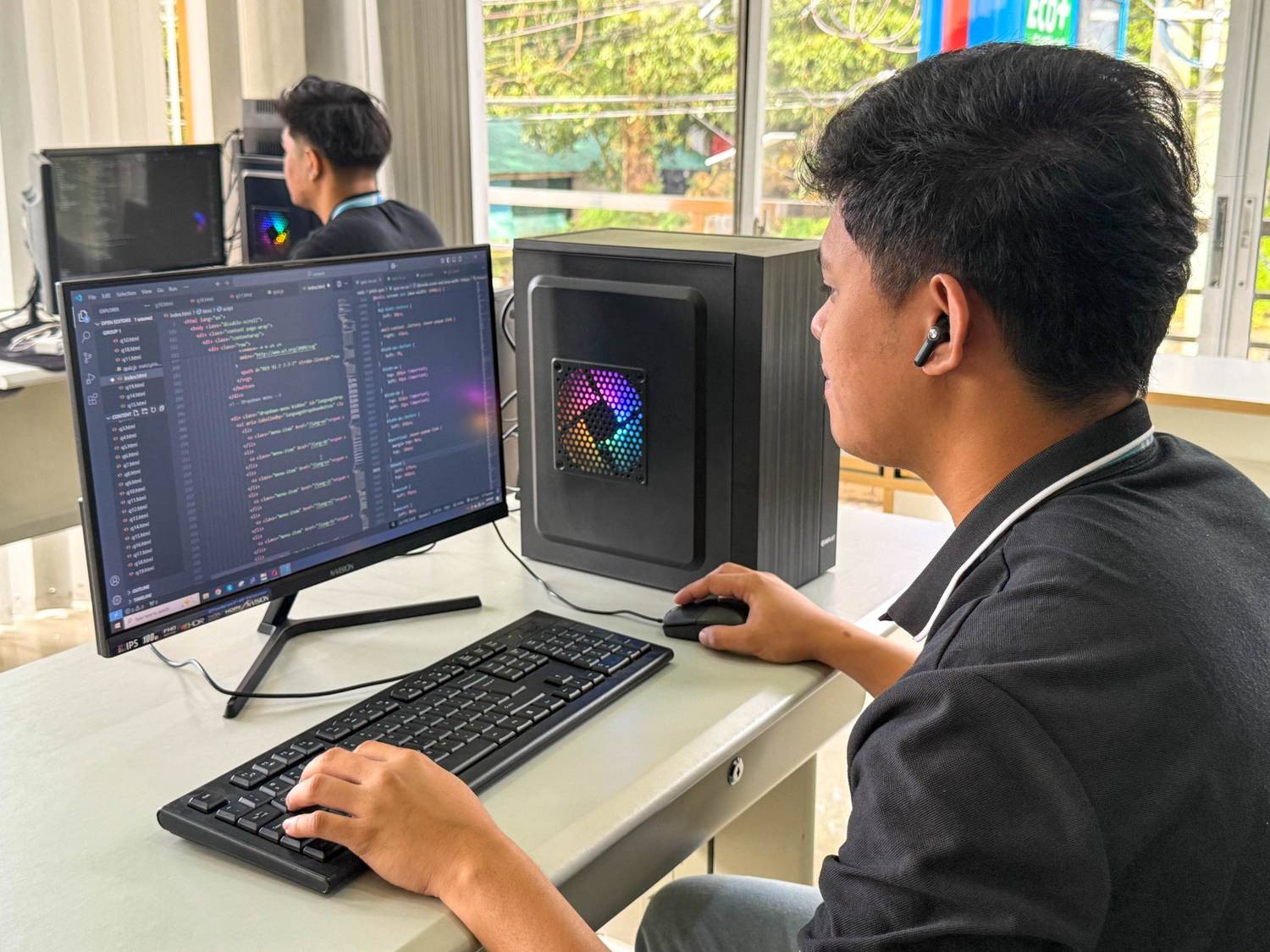 Tech workstation with desktop computer, keyboard, and coding interface for software development.
